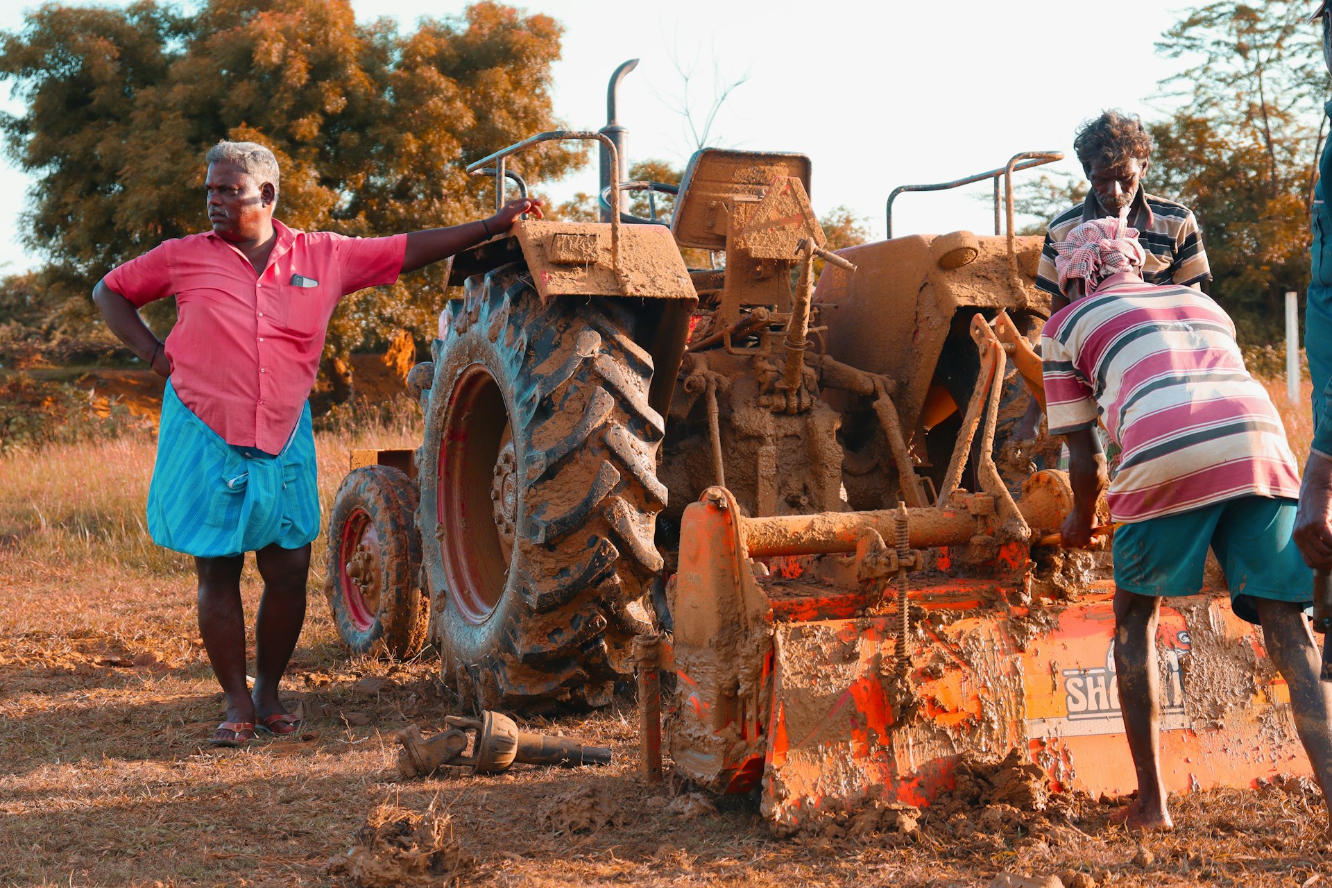 a couple of people standing next to a tractor
